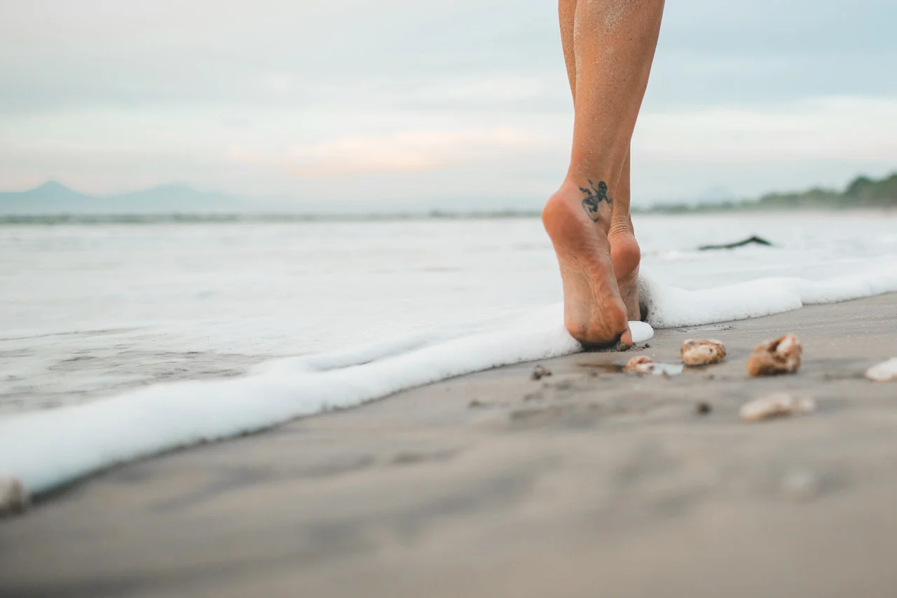 Mulher andando descalça na praia